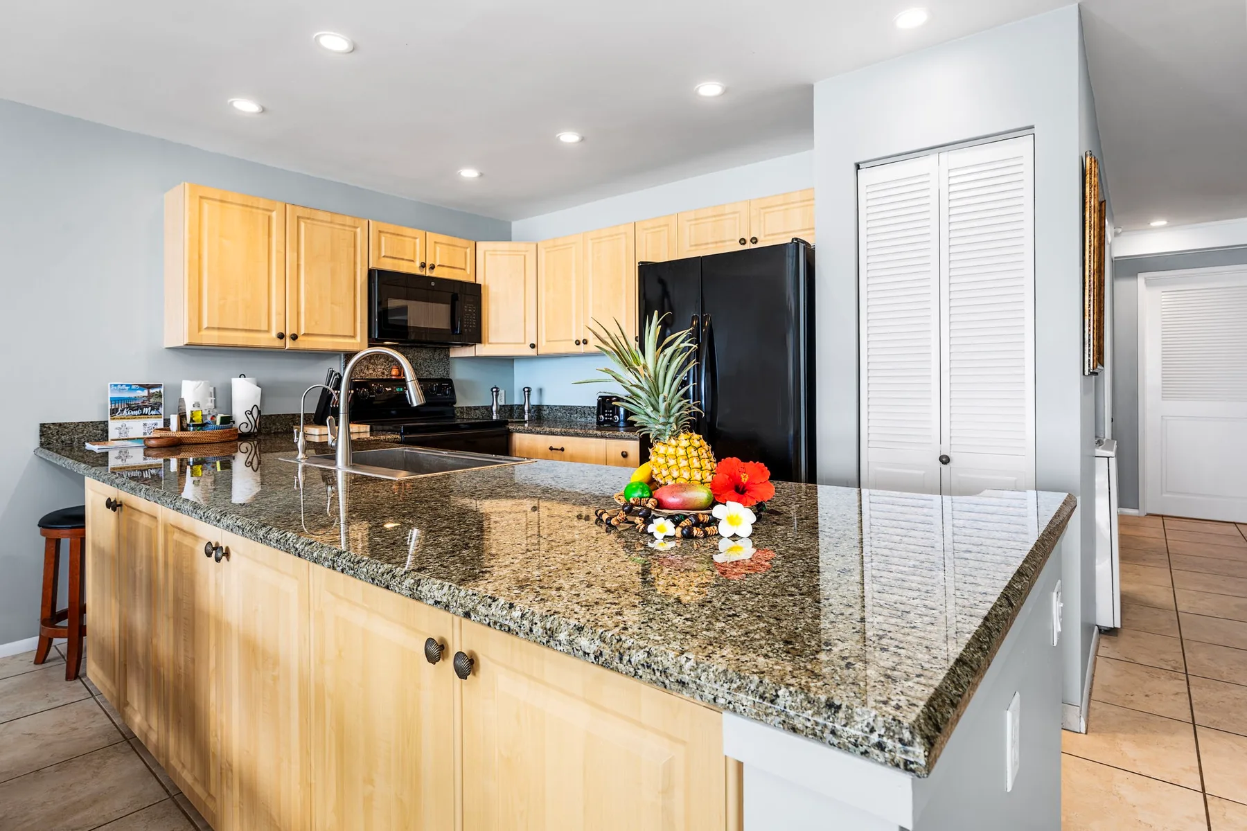 Una cocina luminosa con gabinetes de madera clara y una gran isla.