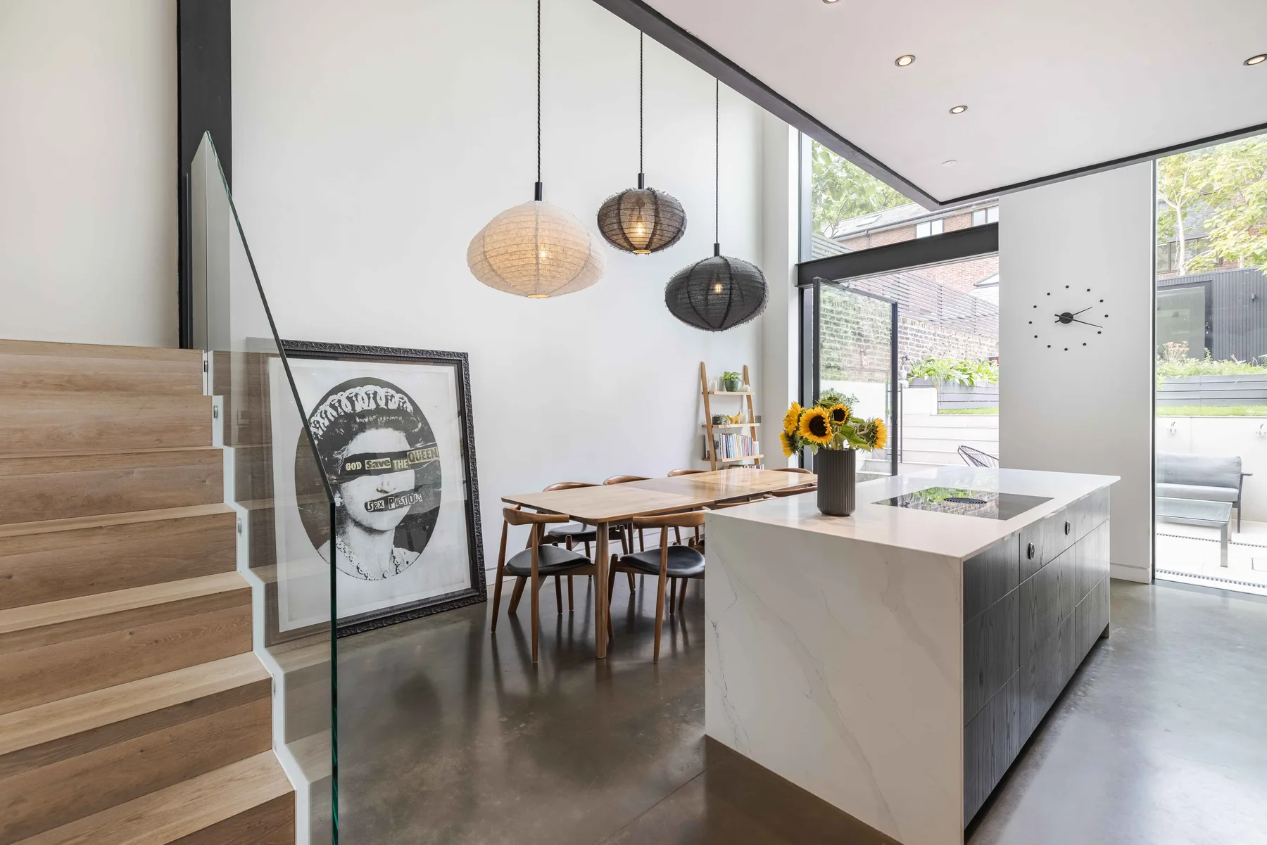 Una cocina y comedor luminosos con una isla central y grandes ventanales.