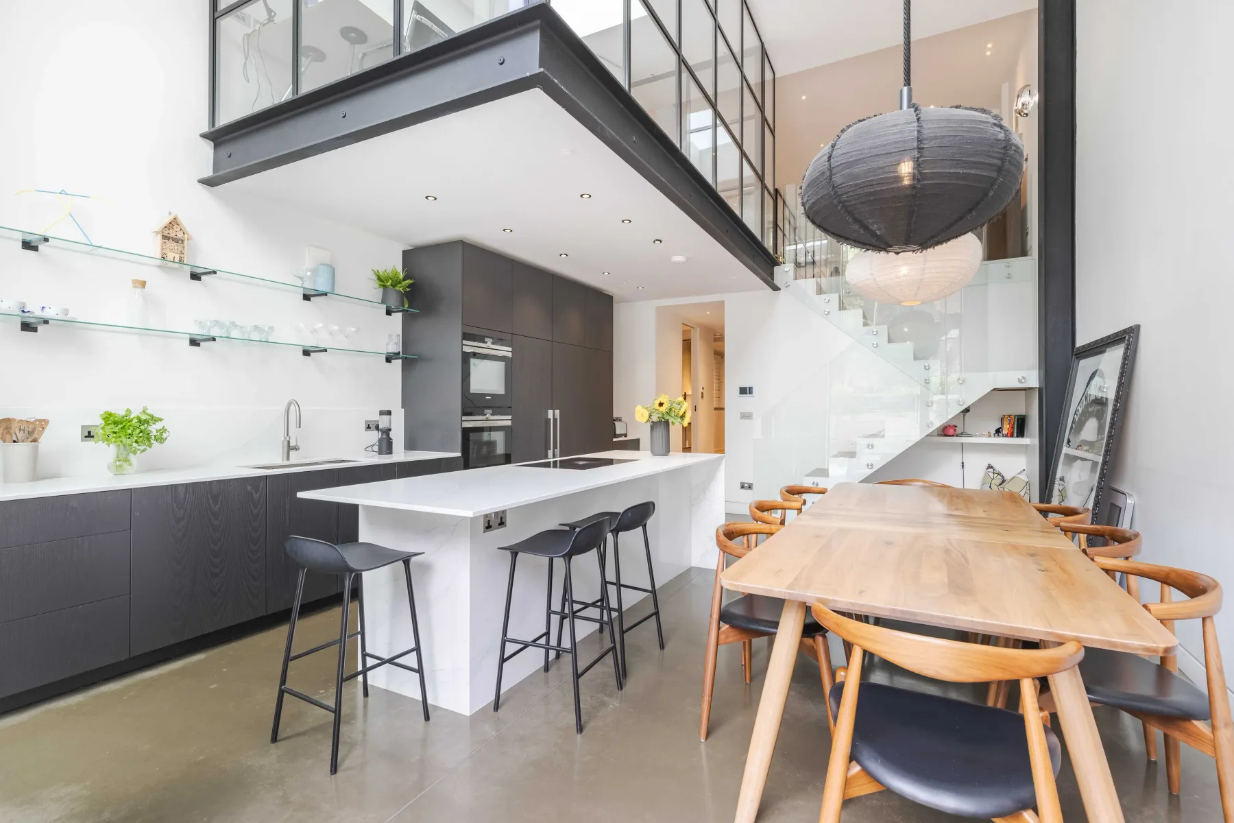Una cocina y comedor diáfanos y luminosos con una larga mesa de madera.