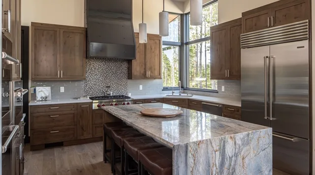 Una cocina con gabinetes de madera oscura, electrodomésticos de acero inoxidable y una isla grande.