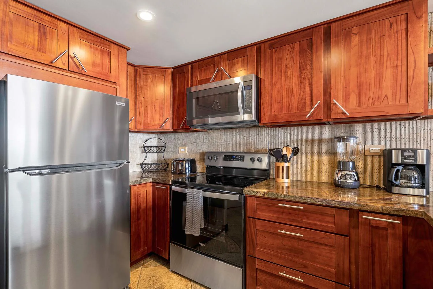 Una cocina con armarios de madera, un refrigerador y una estufa.