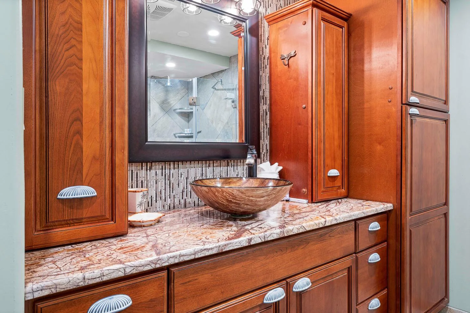 Un tocador de baño con lavabo sobre encimera, superficie y espejo.