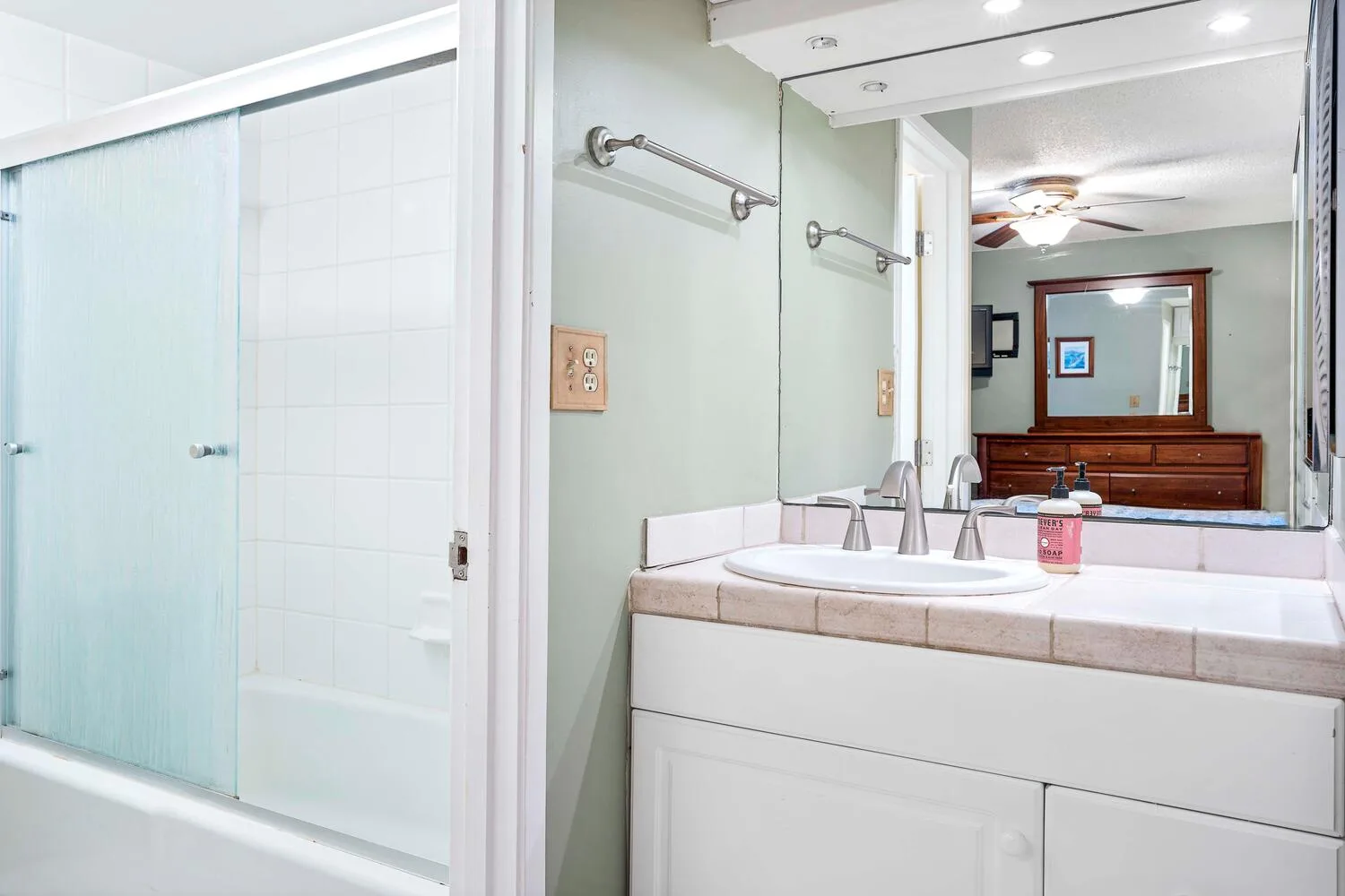 Un baño con lavabo doble y una ducha con mampara de vidrio.
