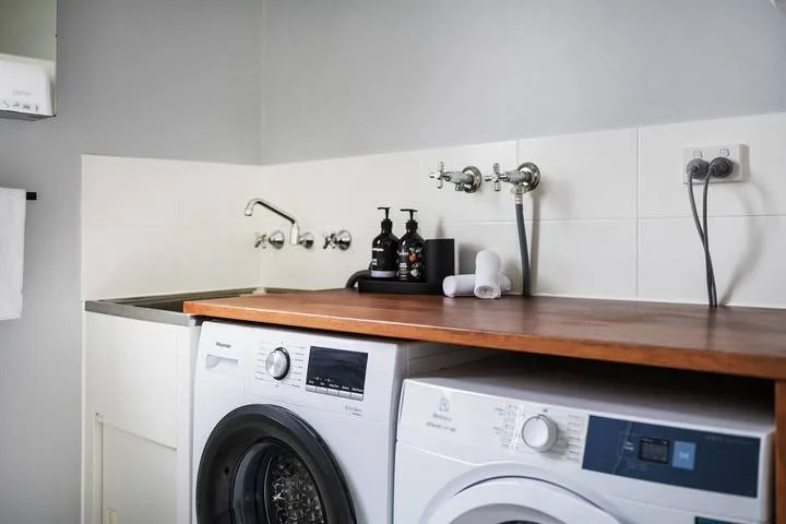 A laundry area with two front-loading washing machines beneath a countertop.