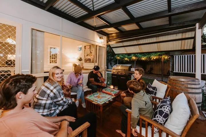 A covered outdoor seating area with people gathered around a low table.
