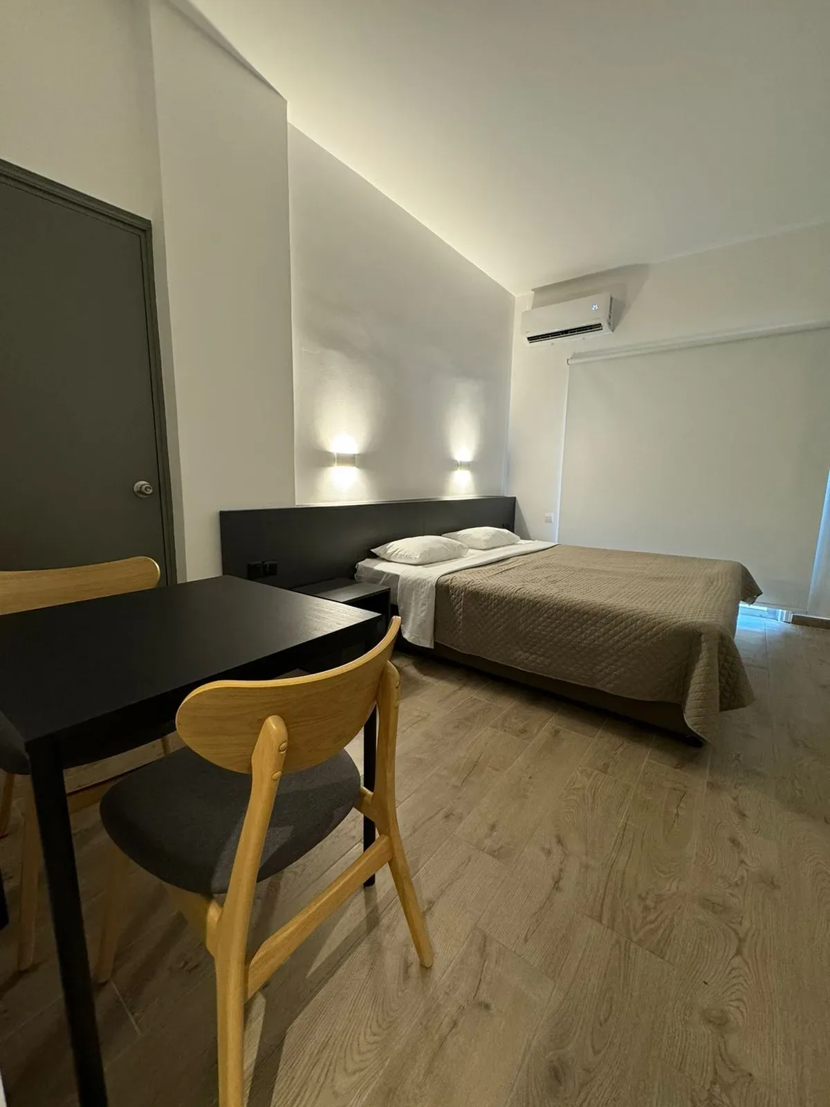 Habitación de hotel con cama, mesa y sillas.