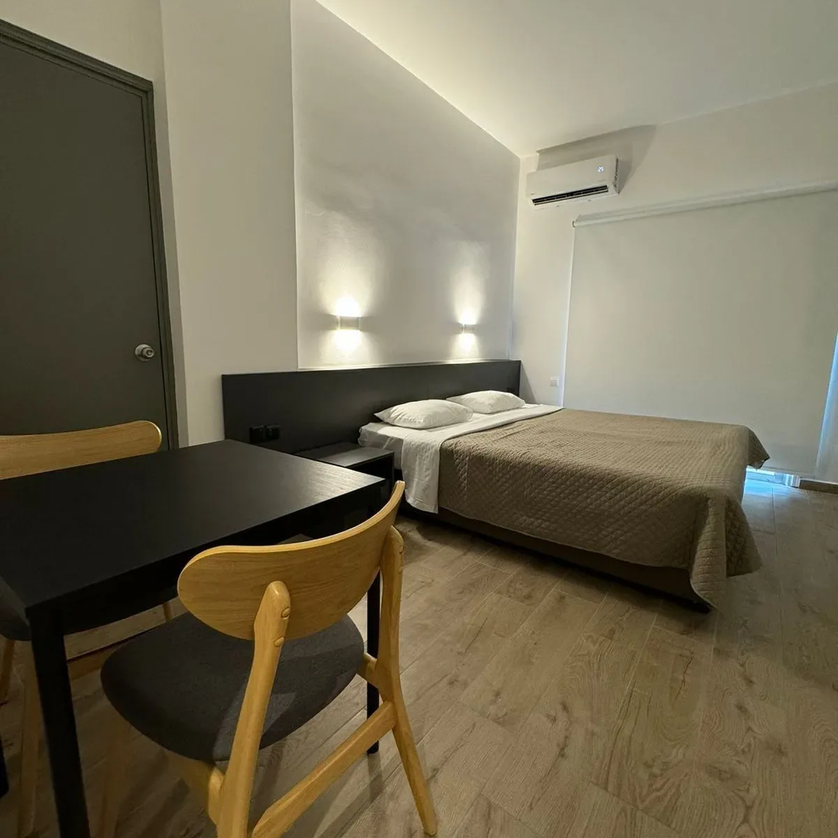 Apartamento tipo estudio con cama, mesa y sillas.