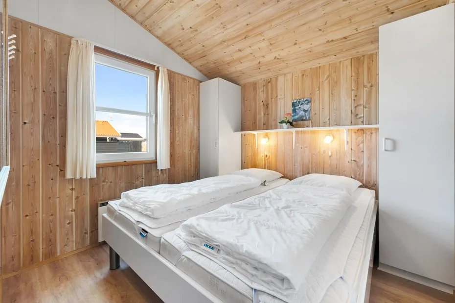 Un dormitorio con dos camas bajo un techo de madera inclinado.