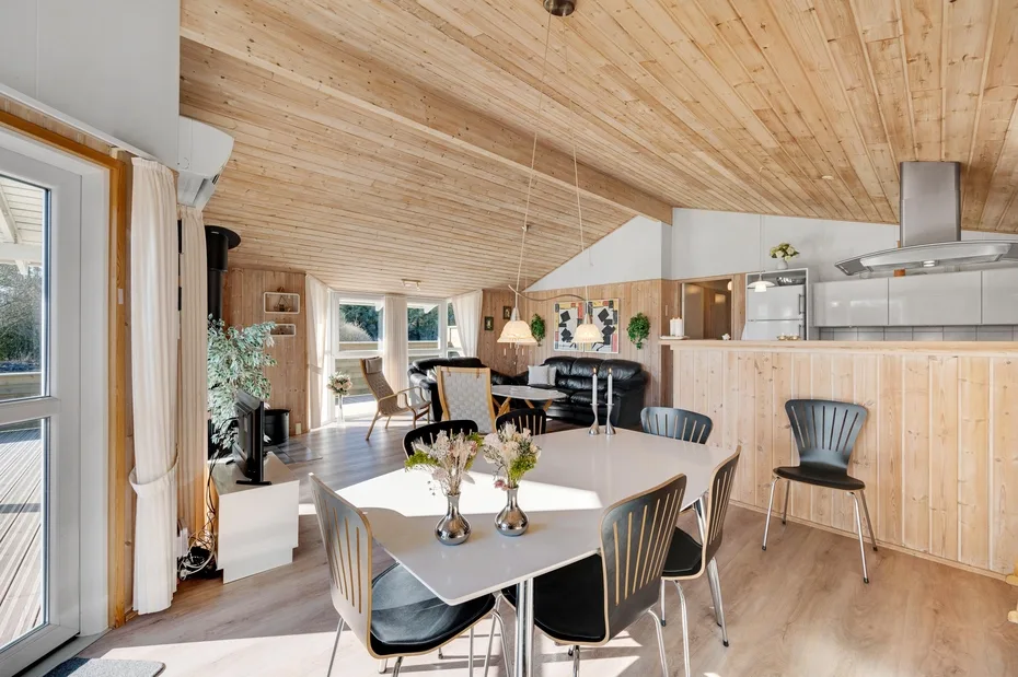 Comedor con mesa y sillas junto a una cocina abierta.