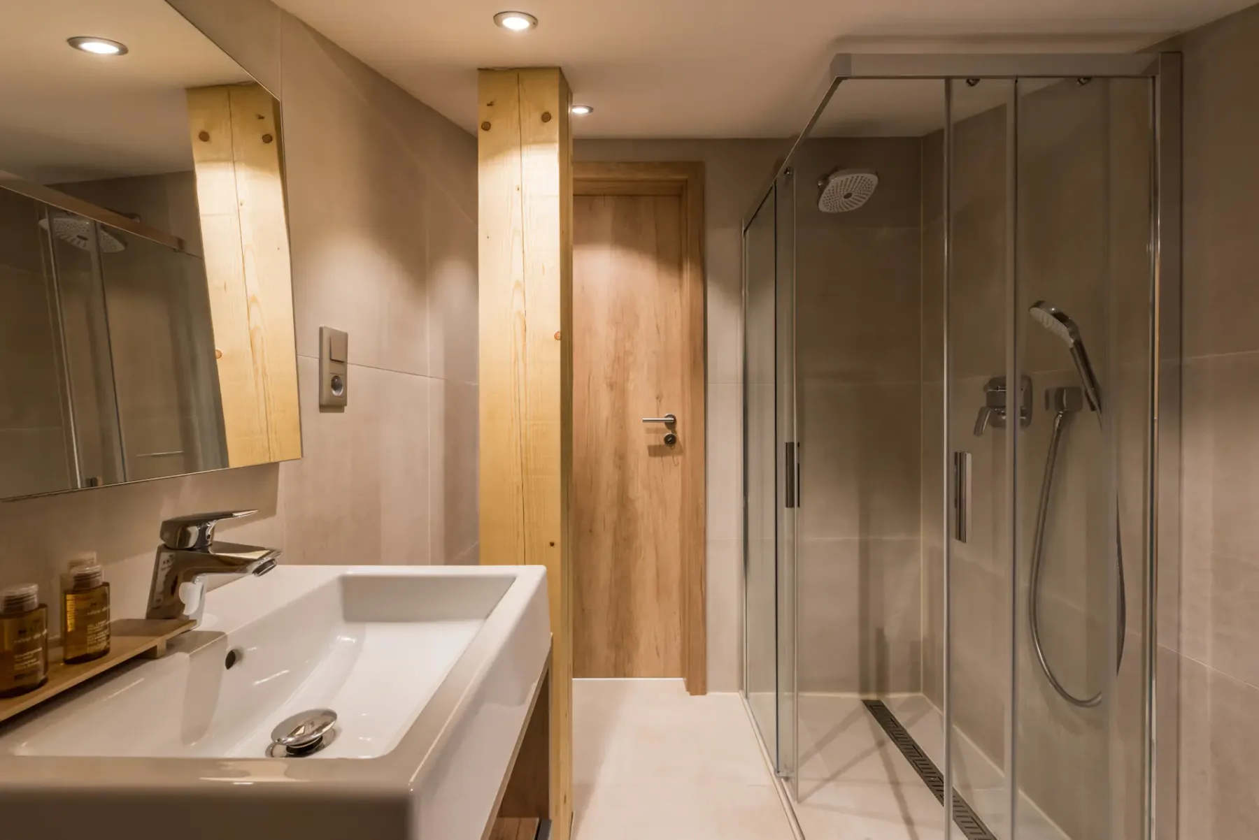 Baño con lavabo, espejo y ducha de cristal.