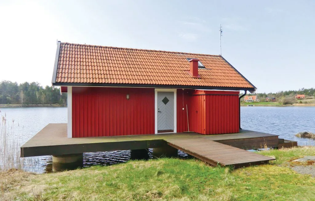 Un edificio rojo junto al agua se alza sobre una plataforma de madera.