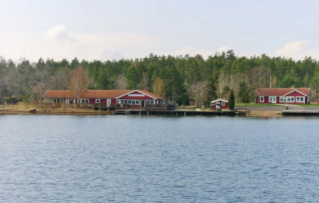 Una escena junto al lago, con edificios rojos en una orilla arbolada.