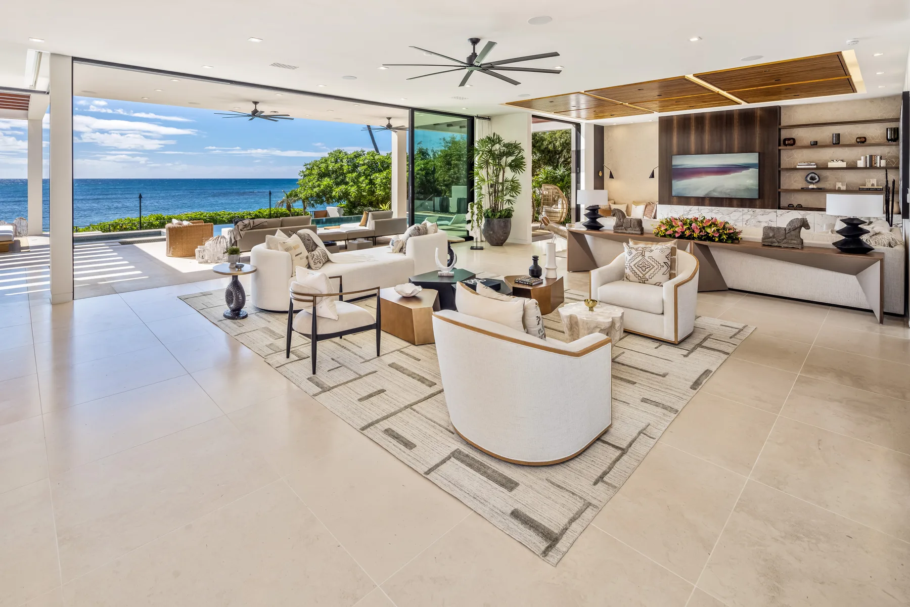 A spacious living room opens onto a patio with views of the ocean.
