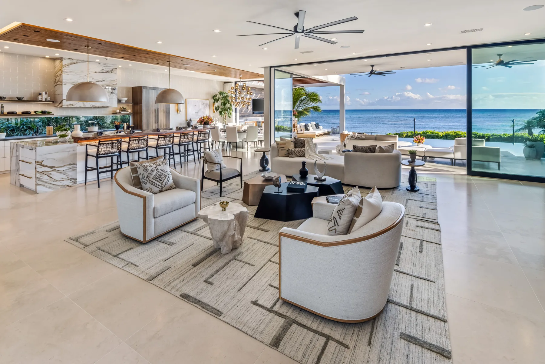 An open-plan living and dining area with large windows overlooking the ocean.