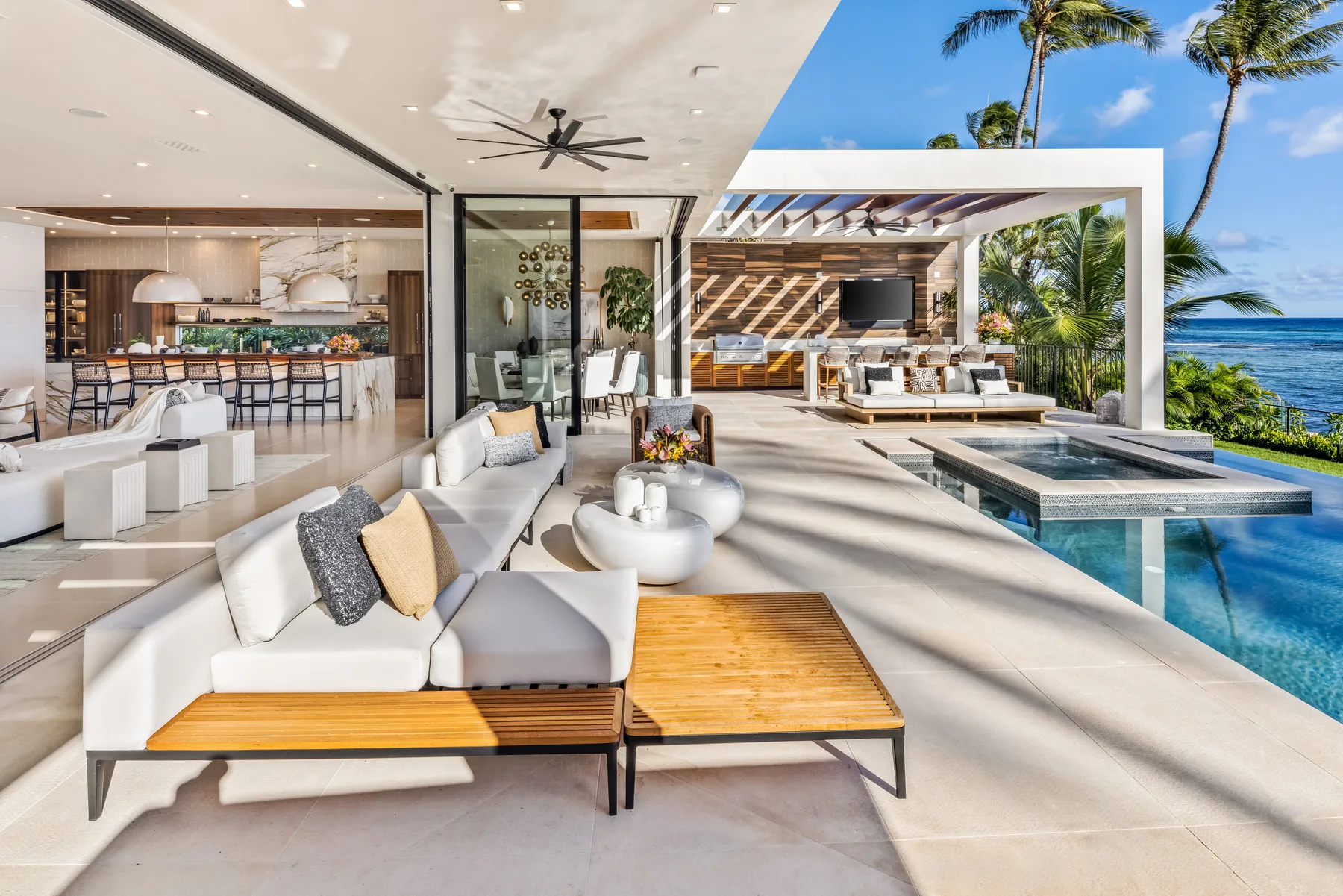An open-plan living area opens onto a patio with a swimming pool.