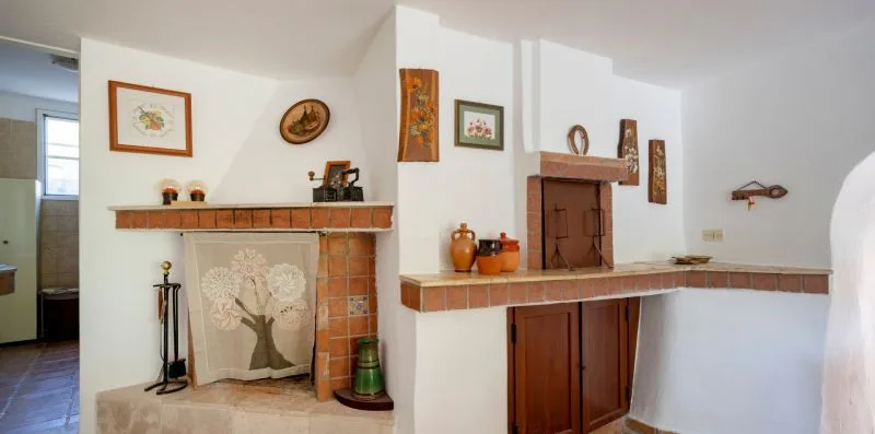 A white interior with a tiled fireplace and a small counter.