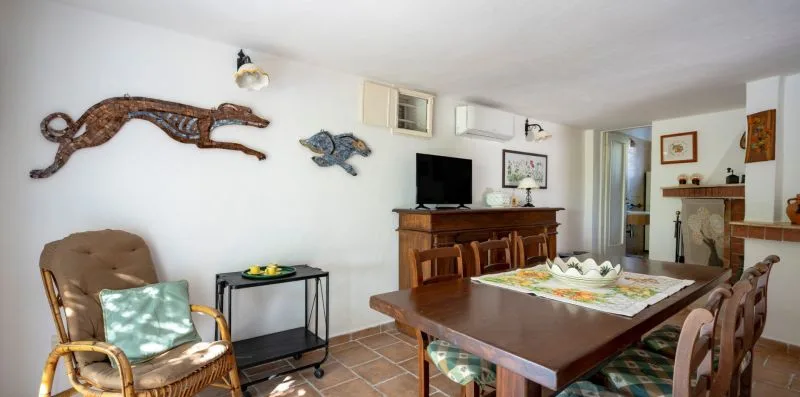 A dining room with a large table and a wooden sideboard.