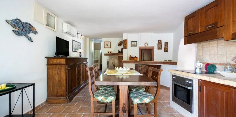 A dining area with a wooden table and chairs beside the kitchen.