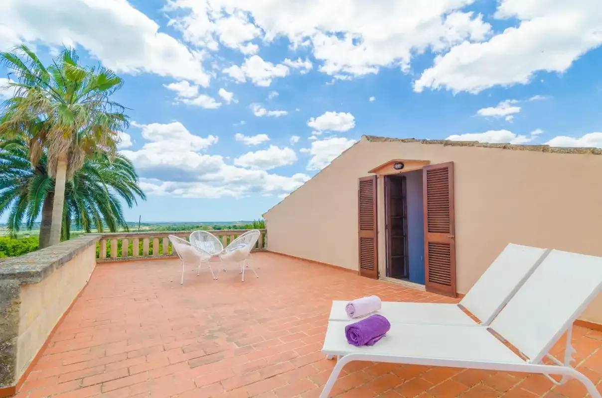 A sunny rooftop terrace with lounge seating and open views of the sea.
