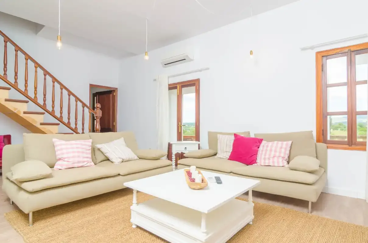 A bright living room with seating around a white coffee table.