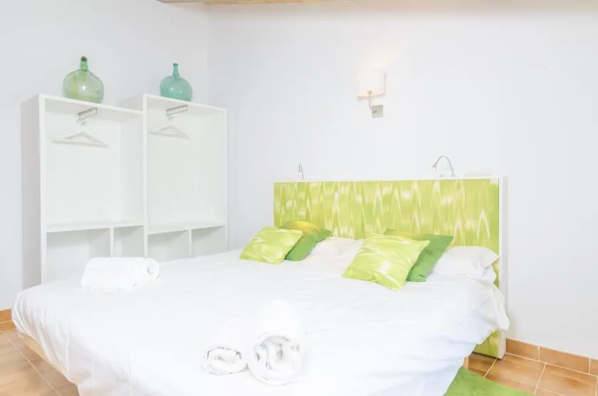 A bright bedroom with a white bed and green accents.