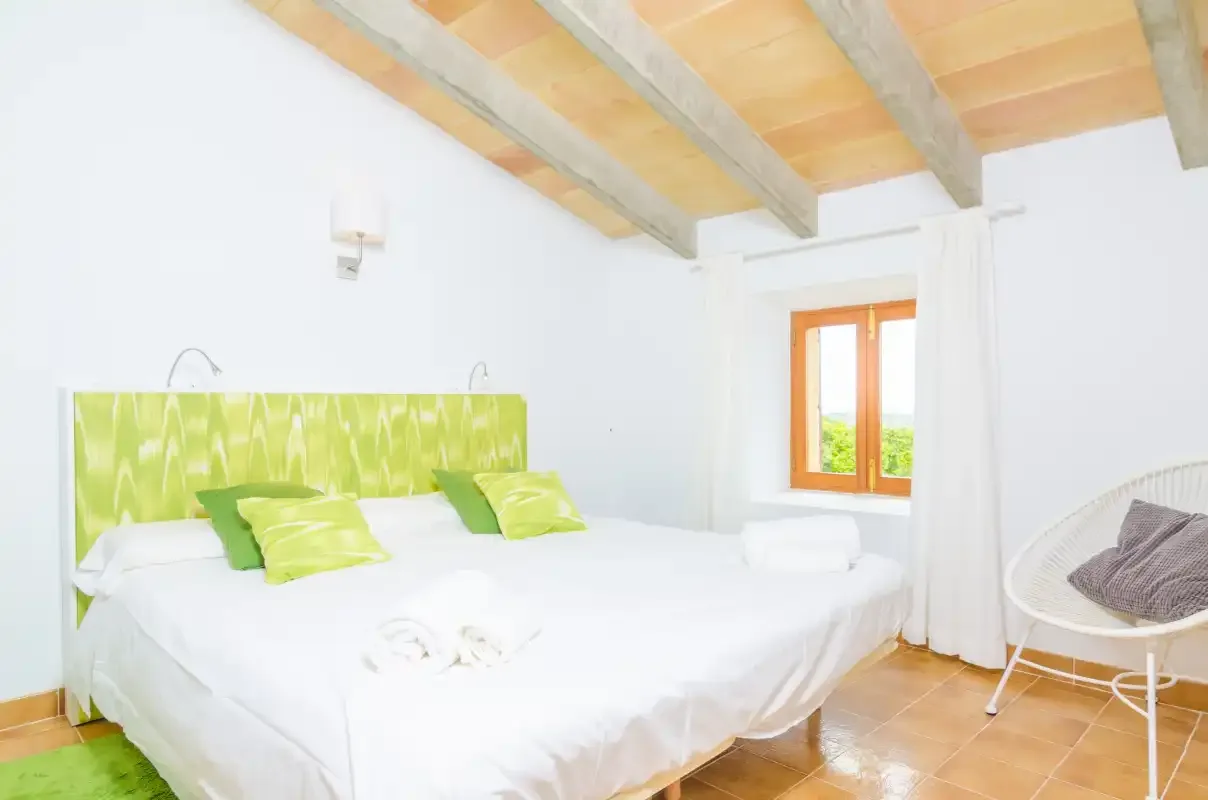 A bright bedroom with a large bed and a window.