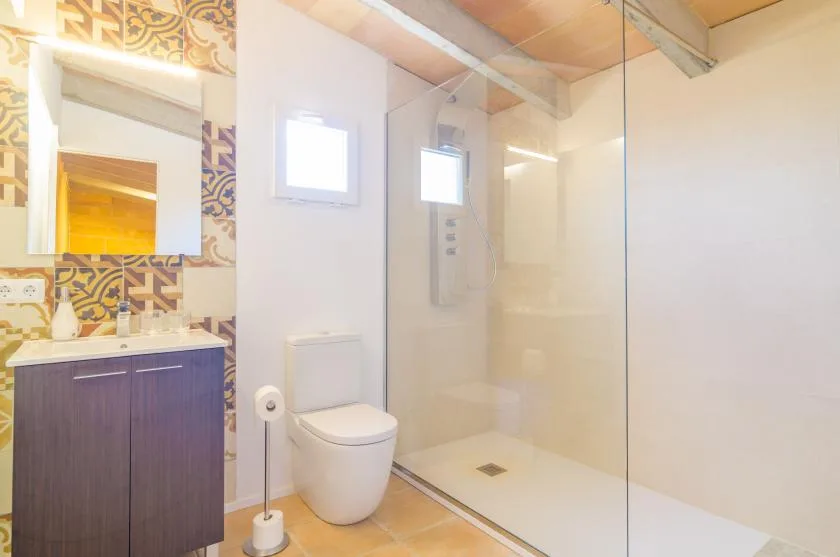 A bathroom with a sink, toilet, and glass-enclosed shower.