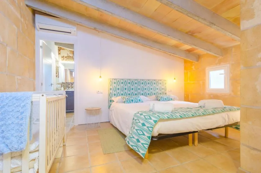 A bedroom with beds dressed in patterned turquoise bedding.