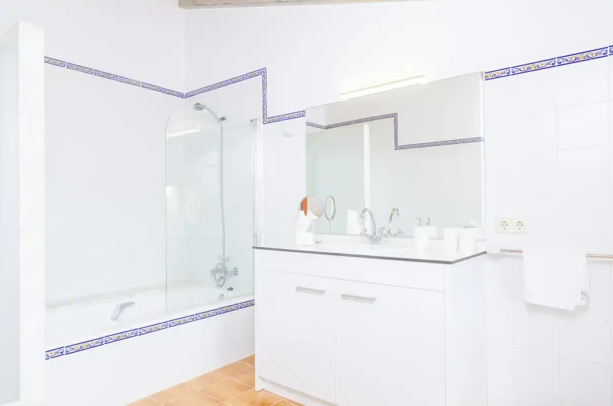 A bright bathroom with a glass shower and a sink vanity.