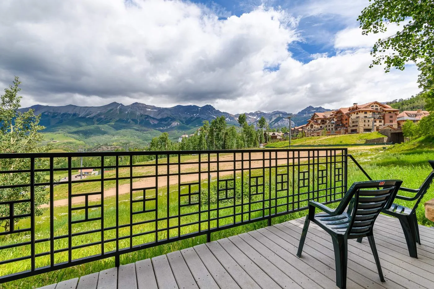 Una terraza con asientos al aire libre da a un valle verde entre montañas.