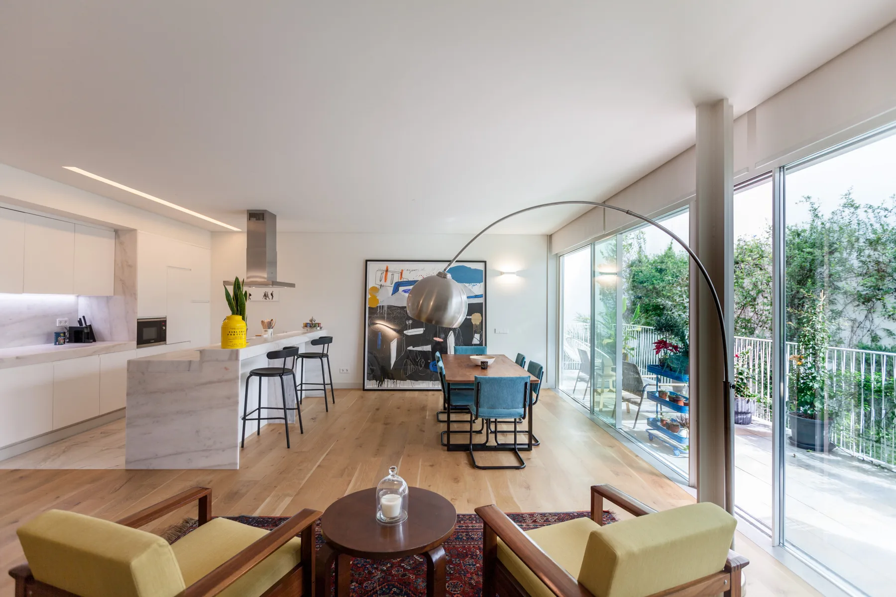 An open-plan living and dining area with seating beside large glass windows.