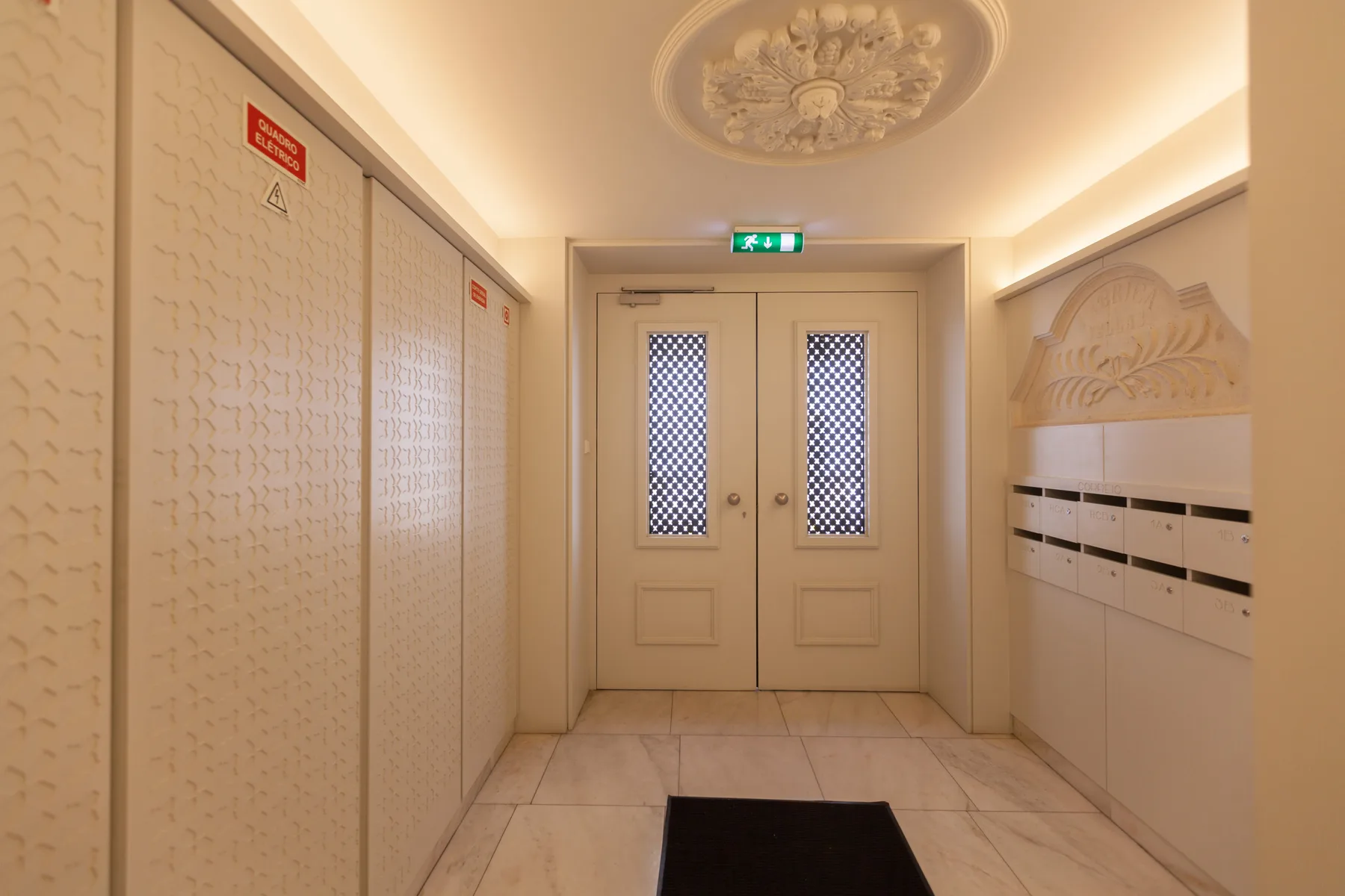 An indoor hallway with patterned doors and a row of mailboxes.