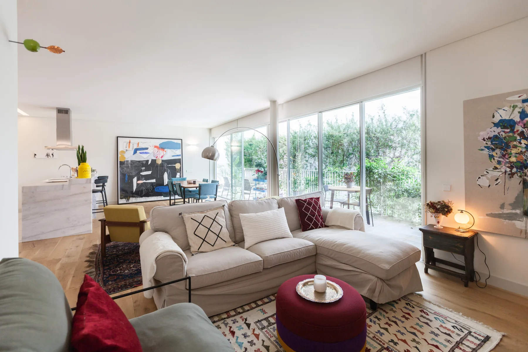 A bright living room with a sectional seating area beside large windows.