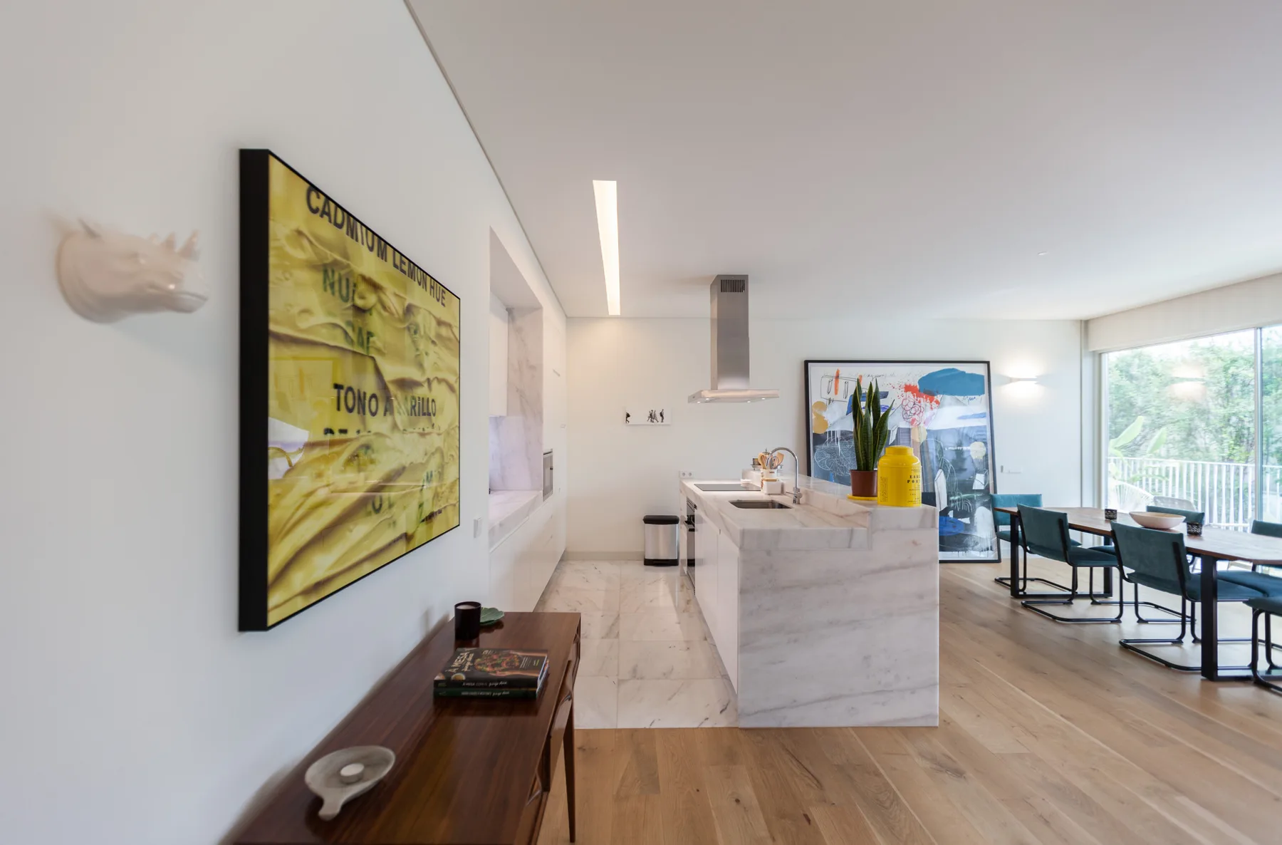 A bright open-plan kitchen and dining area with large windows and a long island.