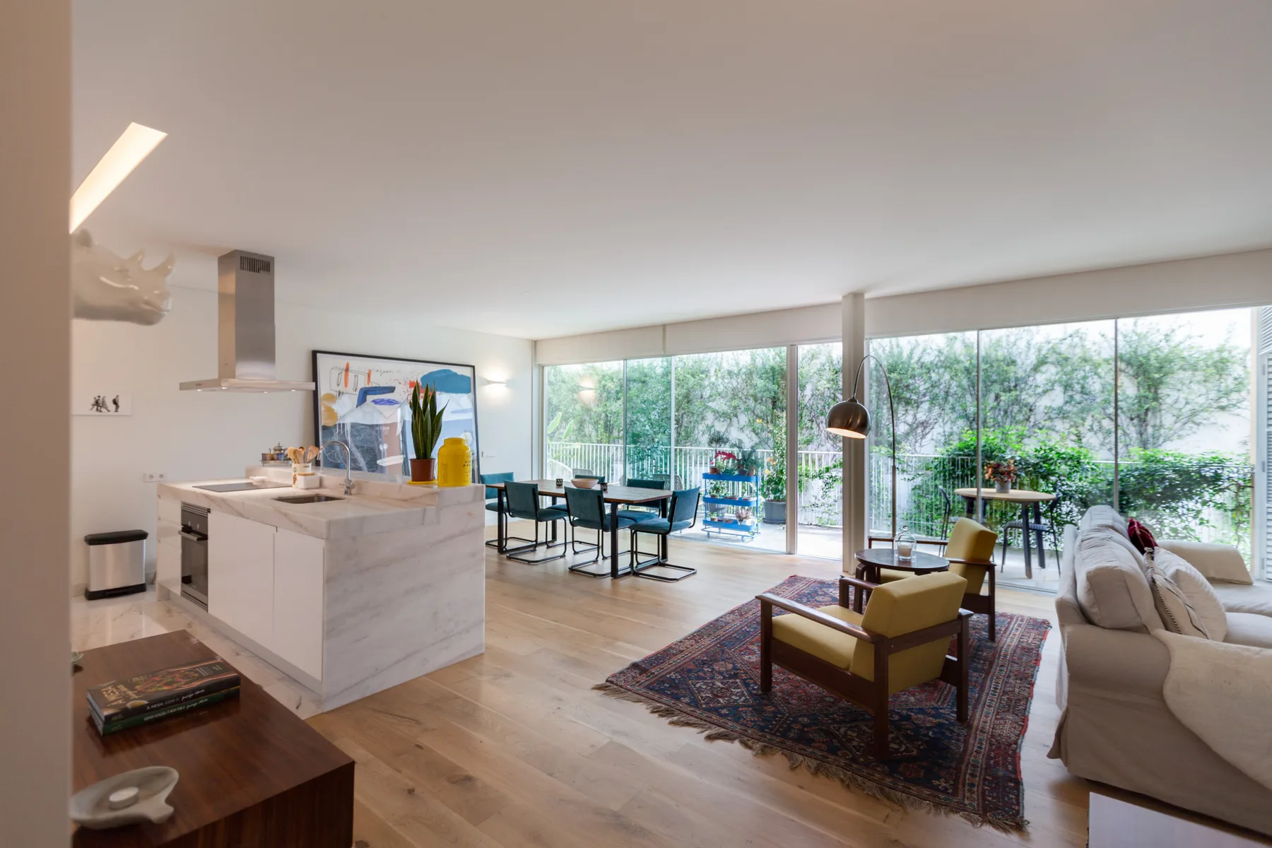 An open-plan living and dining area with a kitchen and large glass windows.