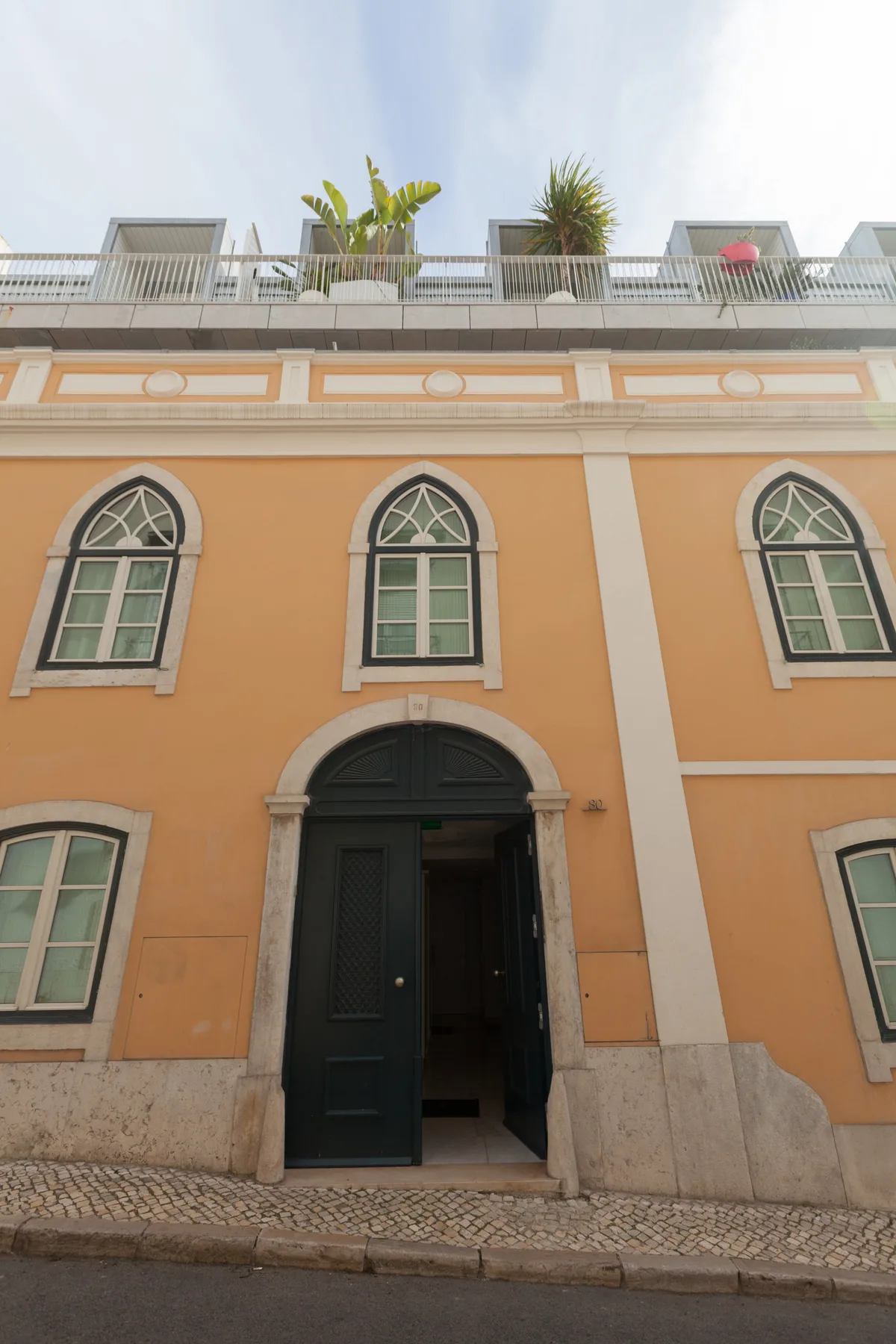 An orange building facade with arched windows and a dark entrance.