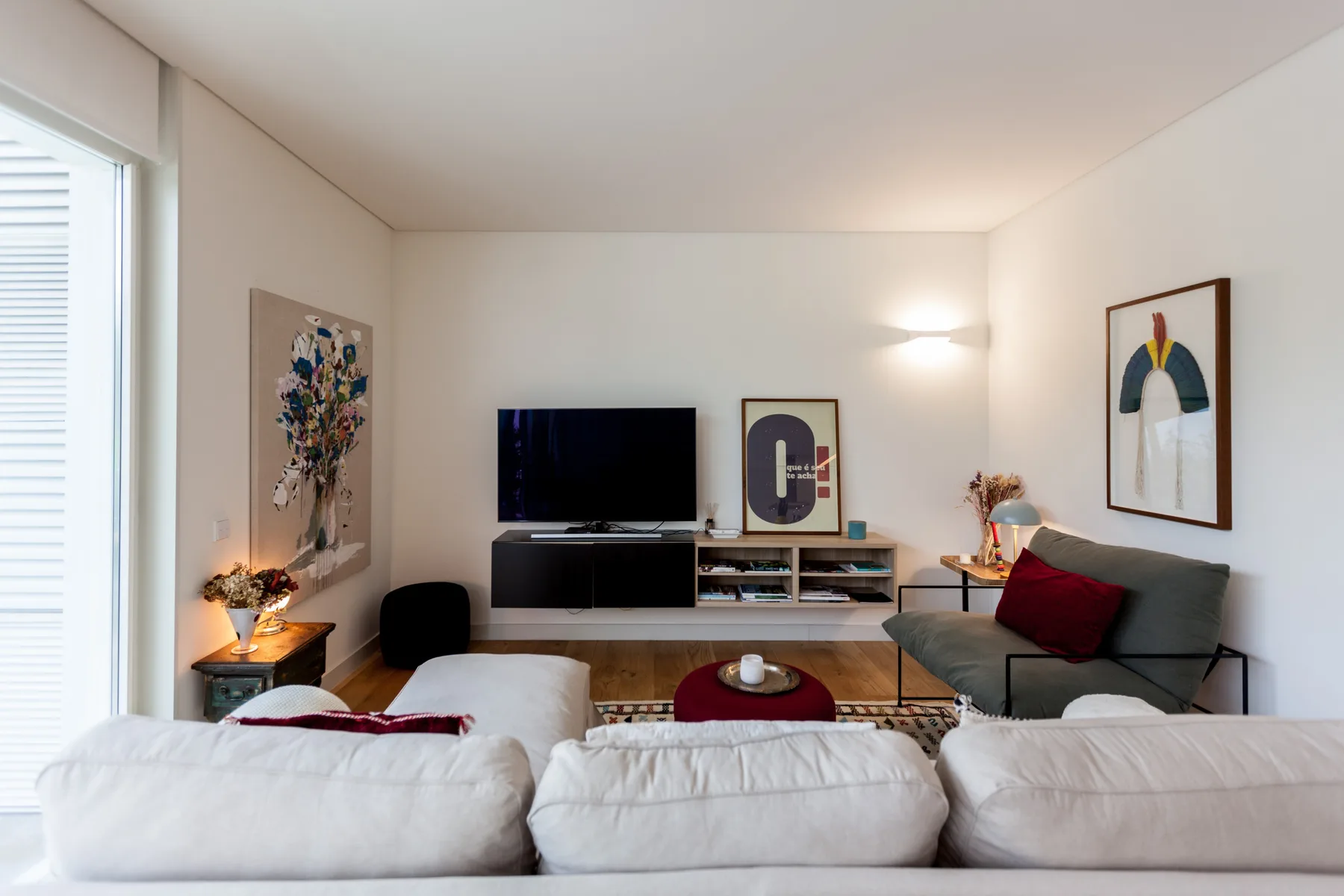 Sala de estar con asientos, un televisor y arte en las paredes.