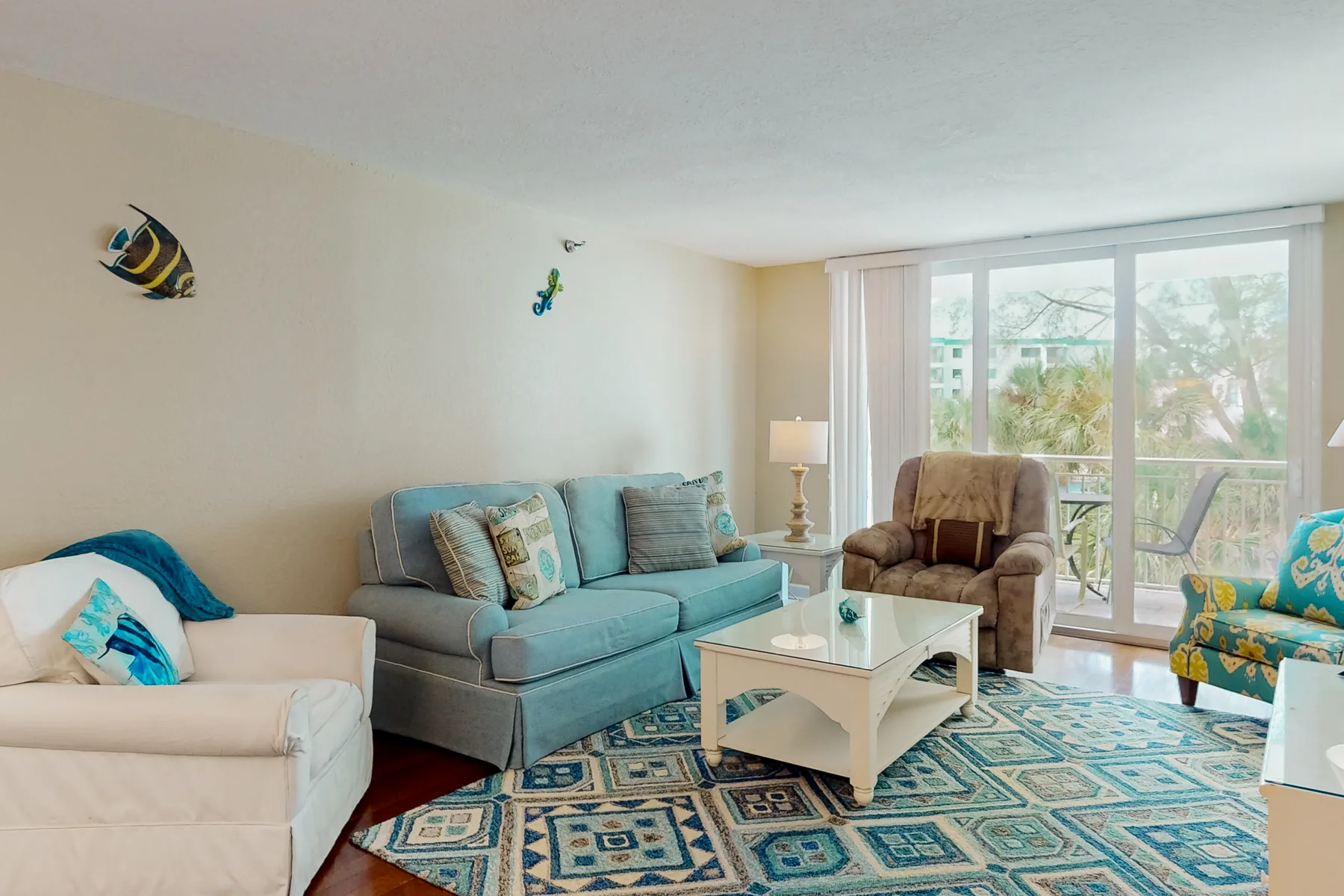 A living room with seating, a coffee table, and large glass doors.