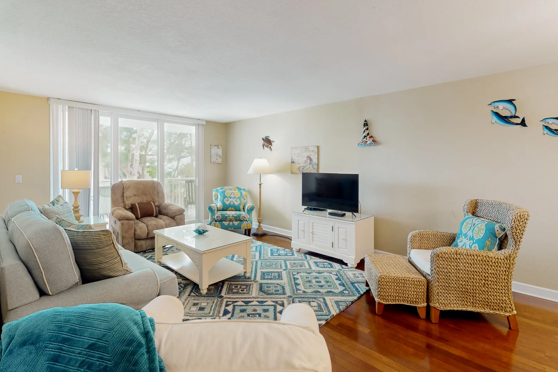 A living room with seating arranged around a coffee table and television.