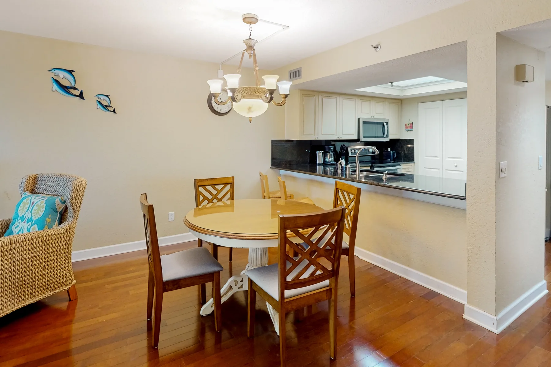 A dining area with a round table and chairs beside an open kitchen.