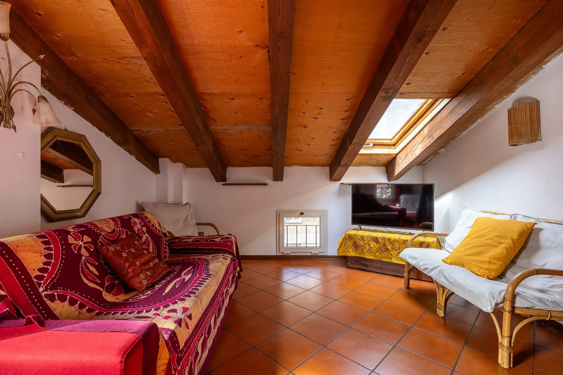 Una sala de estar con asientos bajo vigas de madera expuestas.