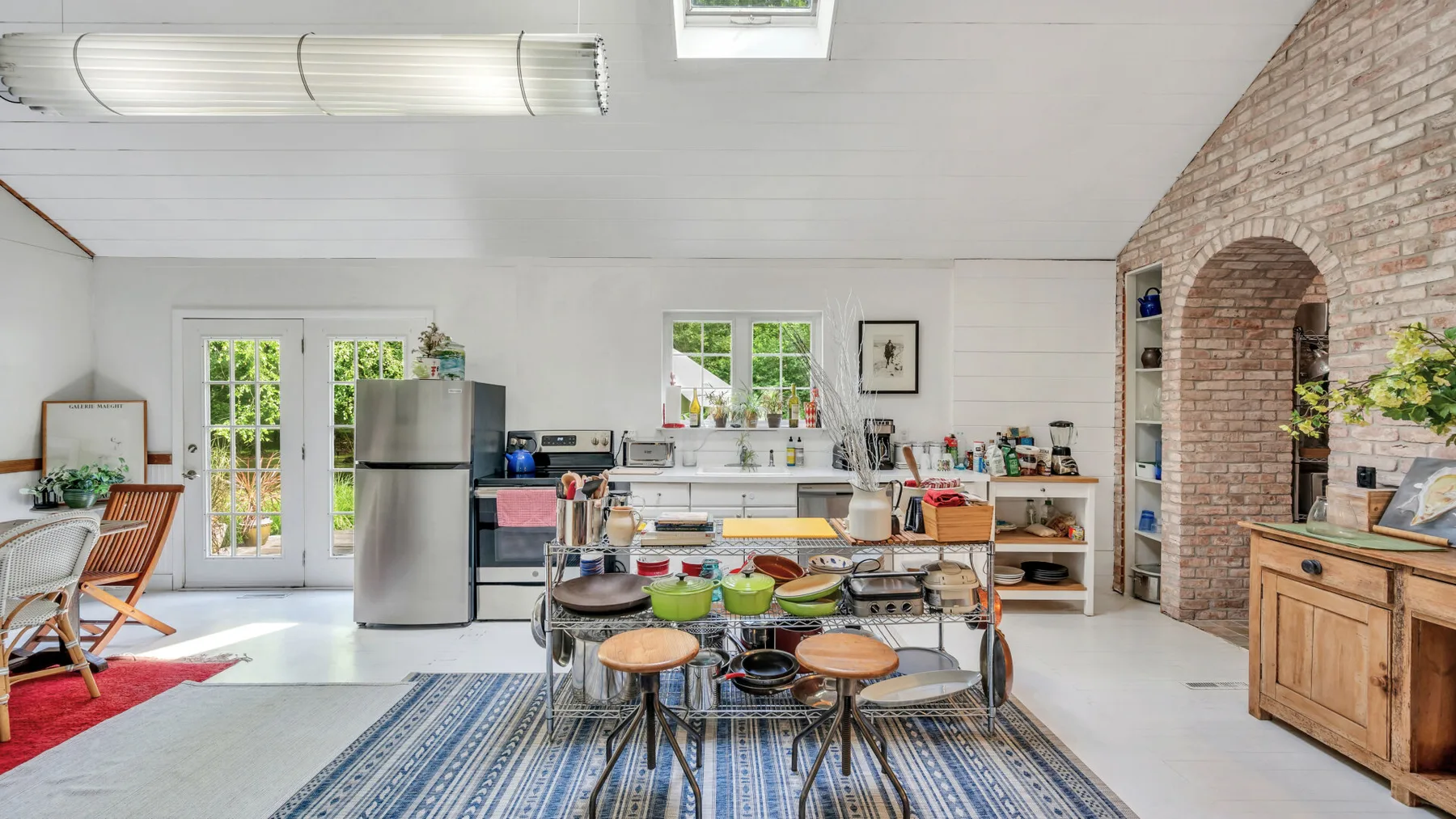 A bright kitchen with a central island and windows along the back wall.