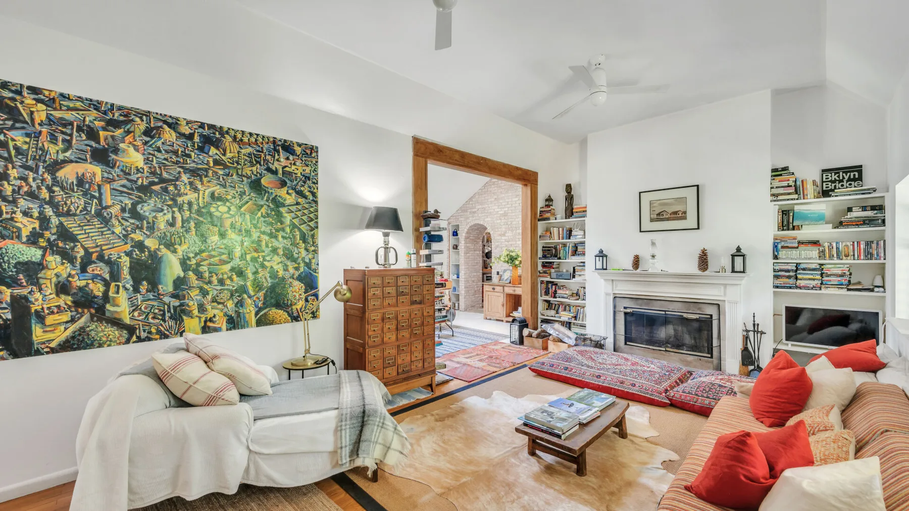 A bright living room with a fireplace, colorful rugs, and seating.