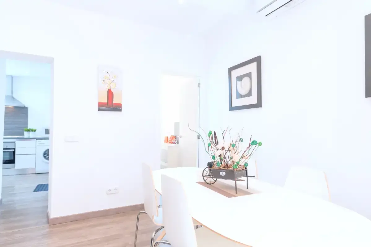 A bright dining area with a white table and decorative centerpiece.