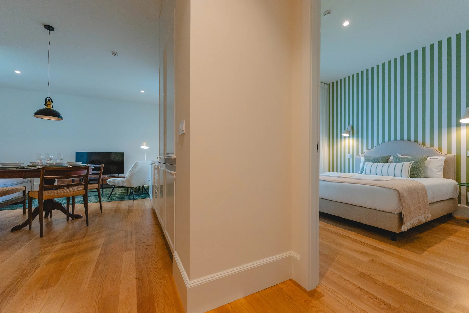 Se ven un dormitorio y un comedor a través de una puerta abierta.
