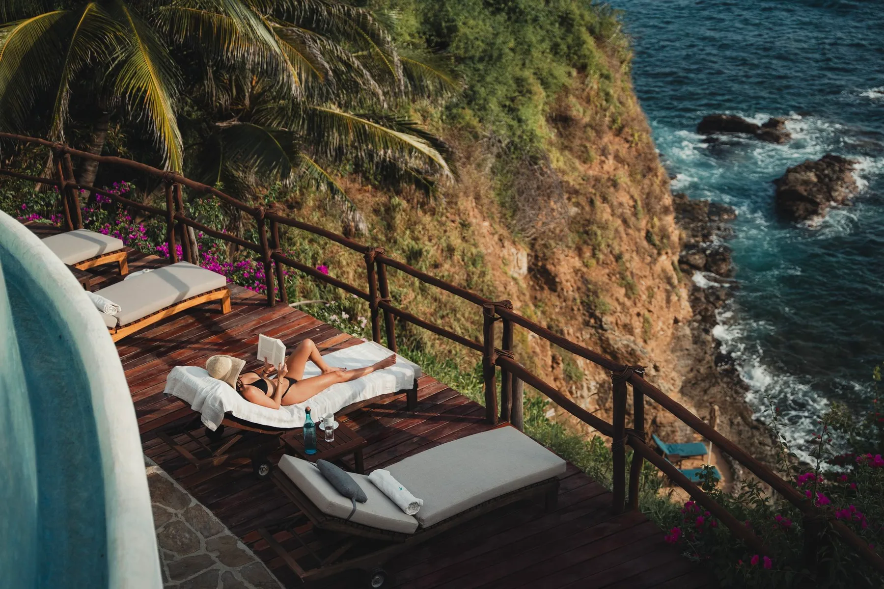 Terraza junto a la piscina con vistas a los acantilados y al océano.