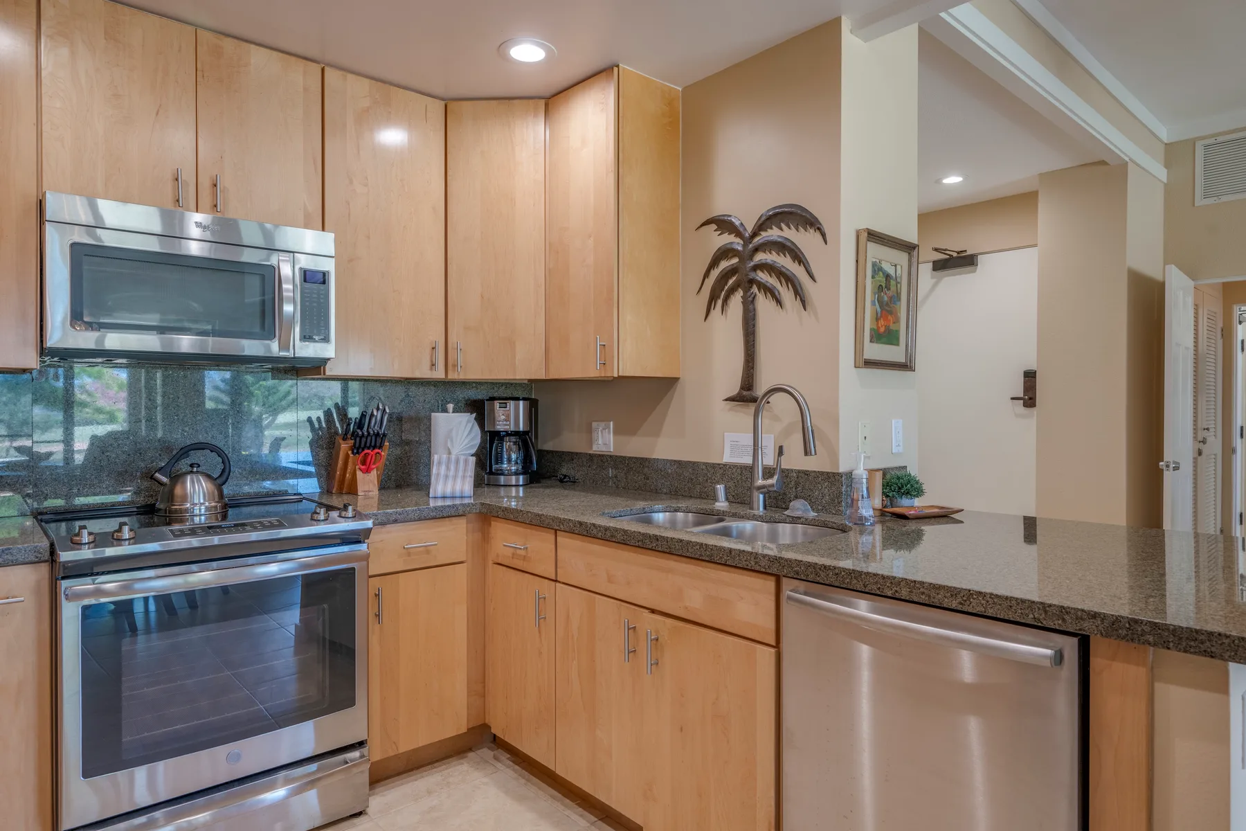 Una cocina con gabinetes de madera, electrodomésticos de acero inoxidable y una encimera.