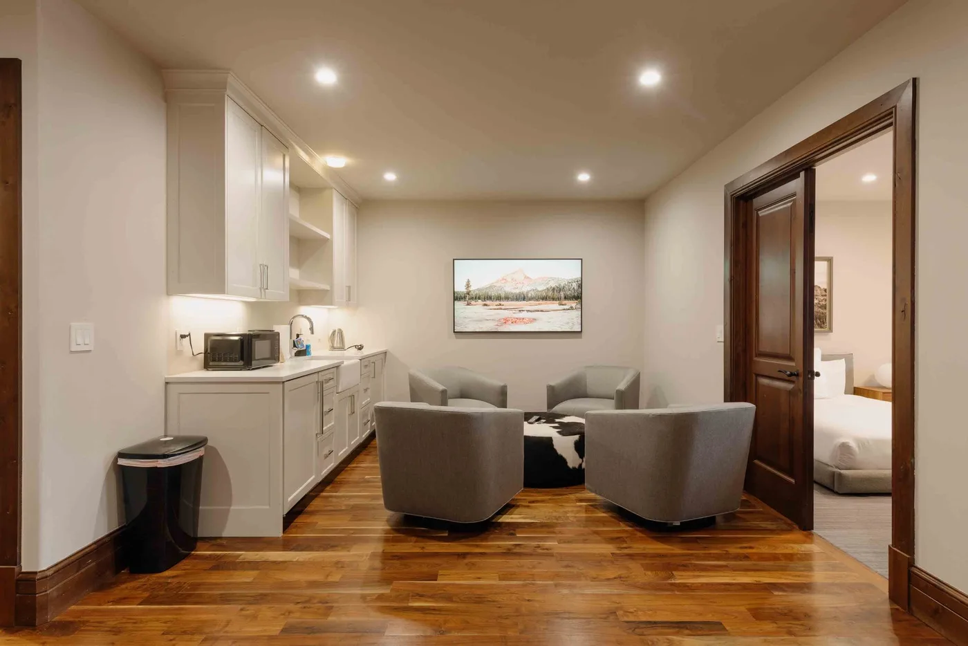 A sitting area with two upholstered seats faces a small table beside a kitchenette.