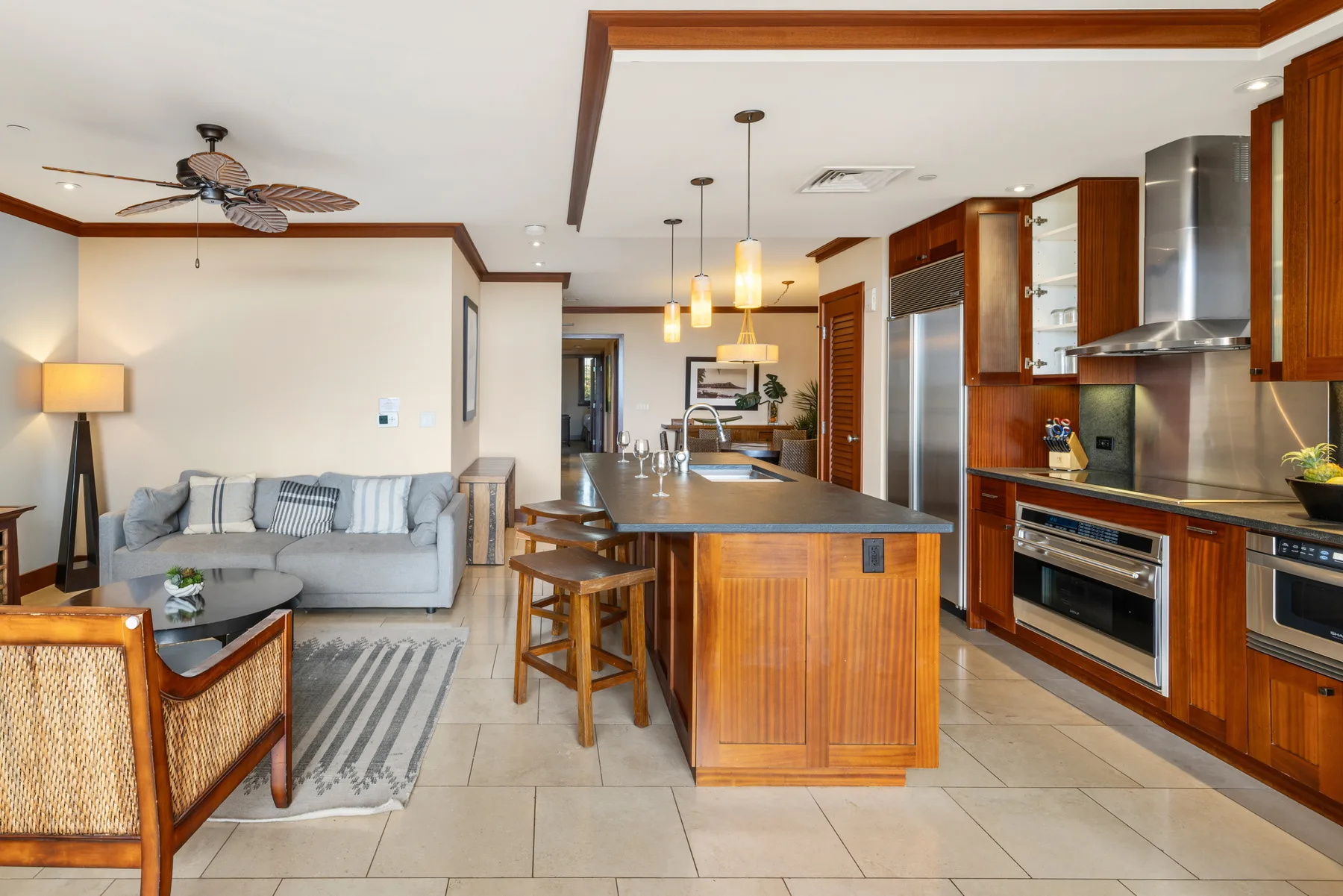 Sala de estar y cocina de concepto abierto con una isla central y asientos.