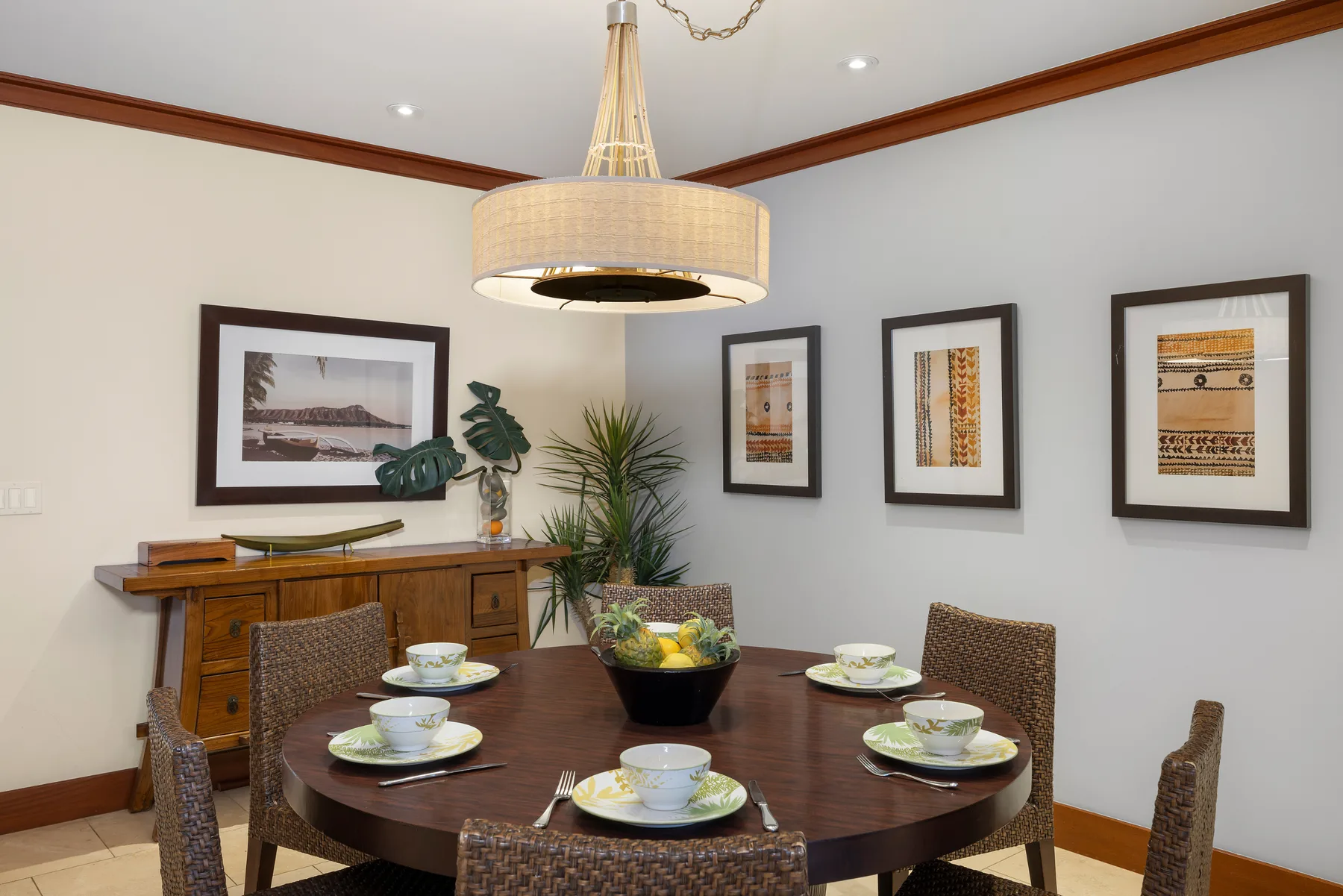 Comedor con una mesa redonda, sillas y cuadros enmarcados en la pared.